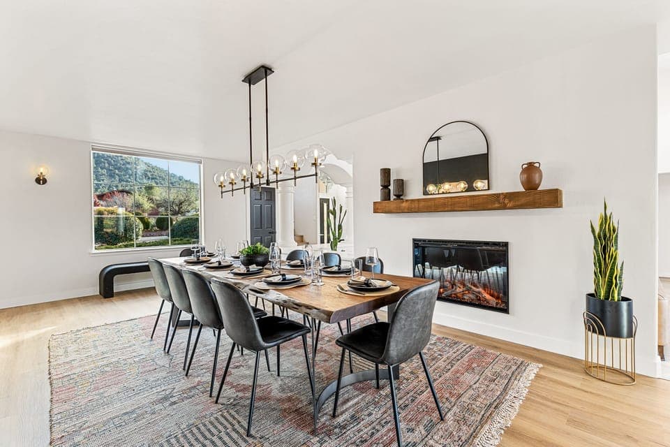 Spacious dining room with a large table, cozy fireplace, and stylish lighting, and Sedona views - perfect for group meals and gathering together.