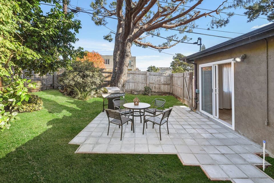 The tiled patio features outdoor seating, making it a perfect spot for BBQs and relaxing in the private yard.