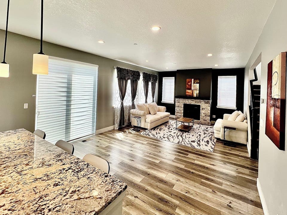 Living room with gas fireplace, hide-a-bed sleeper sofa and motorized blinds.