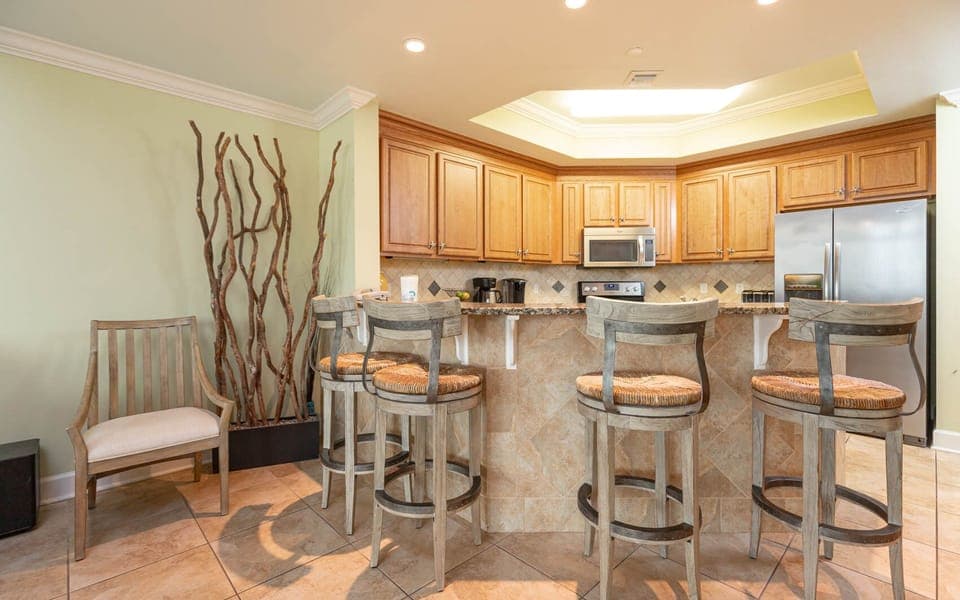 This kitchen features warm wood cabinetry, granite countertops, and a cozy breakfast bar, perfect for morning coffee