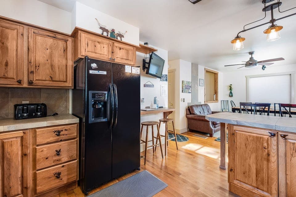 Full refrigerator with water and ice dispenser. A  small wall mounted Tv for entertainment.