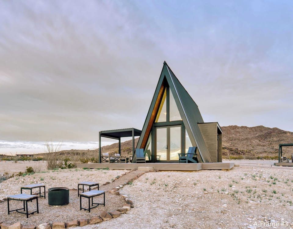 Exterior view of A-Frame #3 front bedroom windows, fire pit and the wrap-around deck