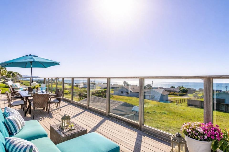 Sun-drenched deck with panoramic water views and cozy seating