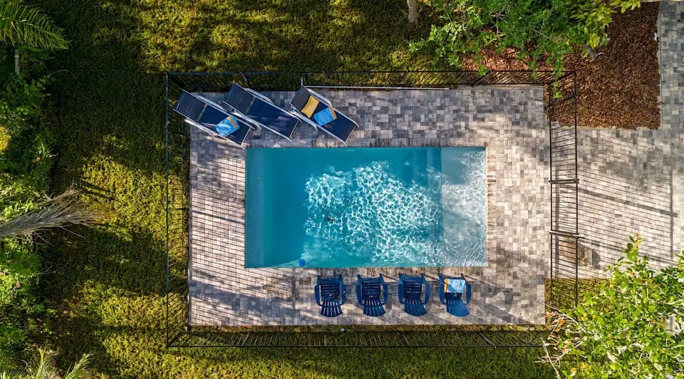 Tucked beneath the oaks, this coastal escape invites slow mornings, sun-filled swims, and easy evenings by the pool—where the unique layout gives everyone room to spread out, reconnect, and make the kind of memories that feel effortless.