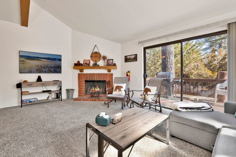 Cozy mountain living room with a fireplace, comfy seating, and smart TV—perfect for relaxing evenings, movie nights, and warm cabin vibes after outdoor adventures.