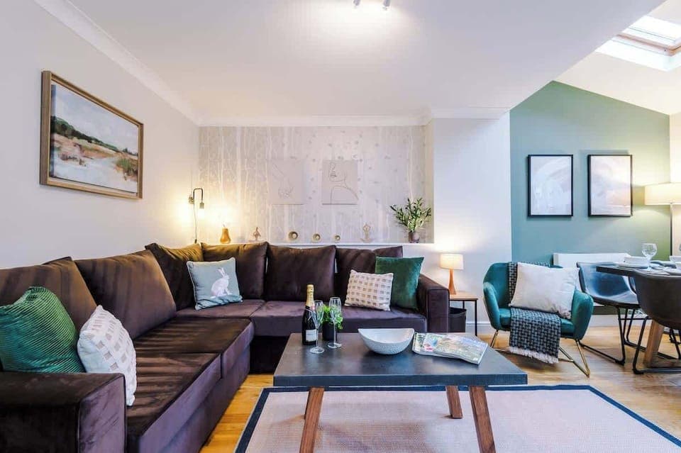 The open-plan living and dining area benefits from a 50-inch SMART TV, a comfortable corner sofa bed, an 8-seater dining table and plenty of space to sit down and relax,
