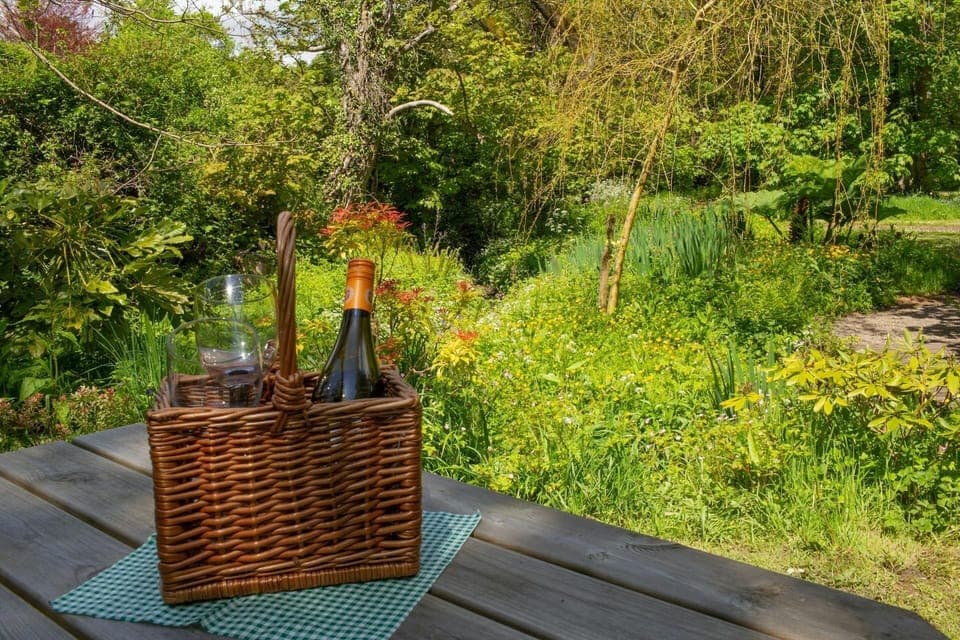 outdoor picnic bench with welcome pack with wine and glasses in wicker basket