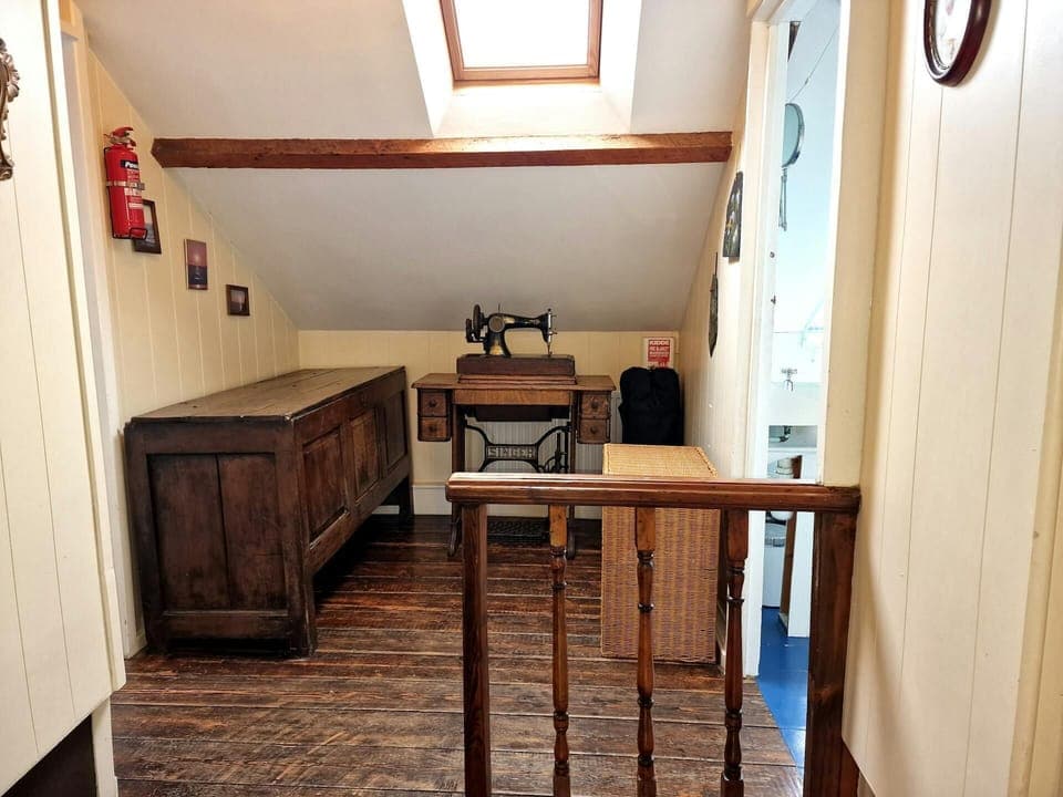 Landing area with wooden floors, velux window and blanket chest