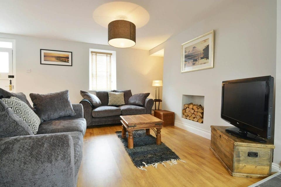 Living room with sofas, TV on wooden trunk and coffee table
