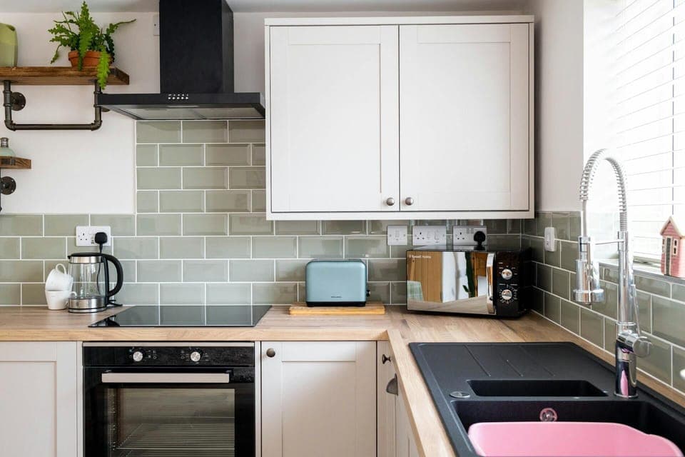 Oven, sink, wall cabinets, floor cabinets, toaster, microwave