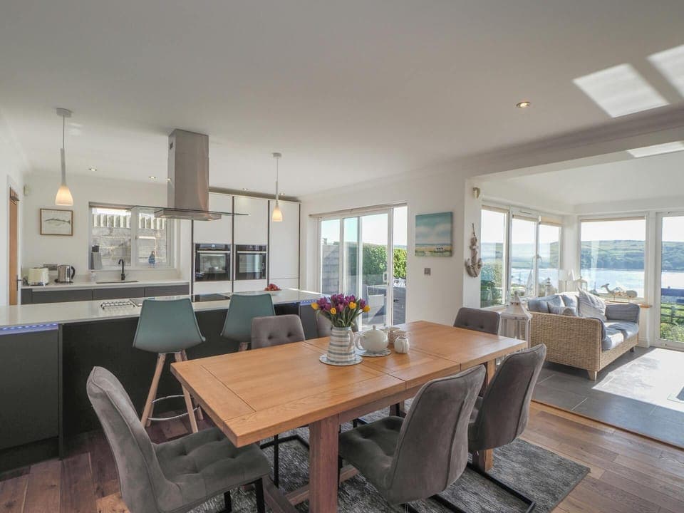 Dining area with table and six chairs, conservatory area with sea view