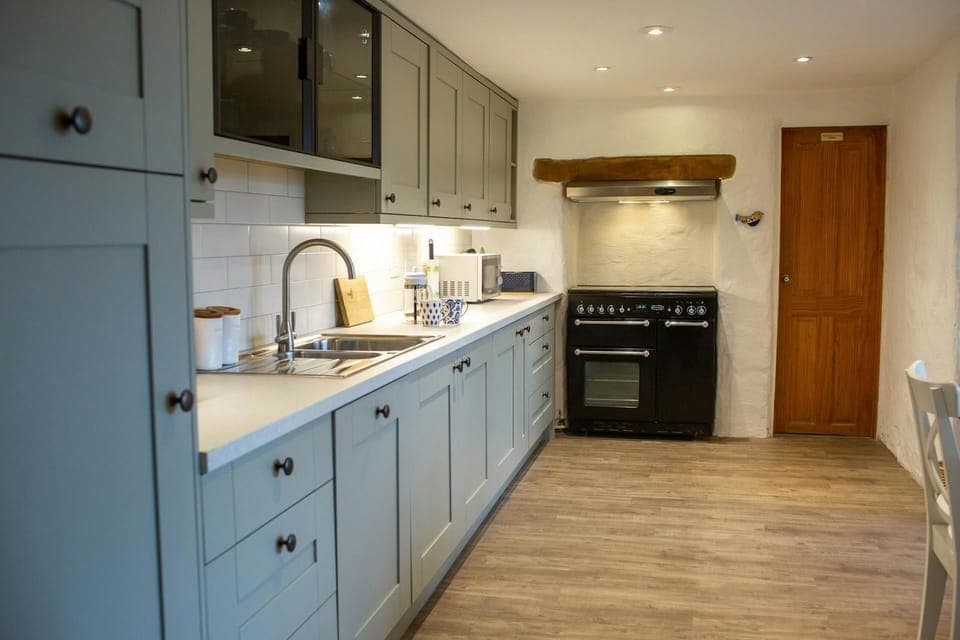 kitchen worktops built in across one wall, large cooker fitted into nook.