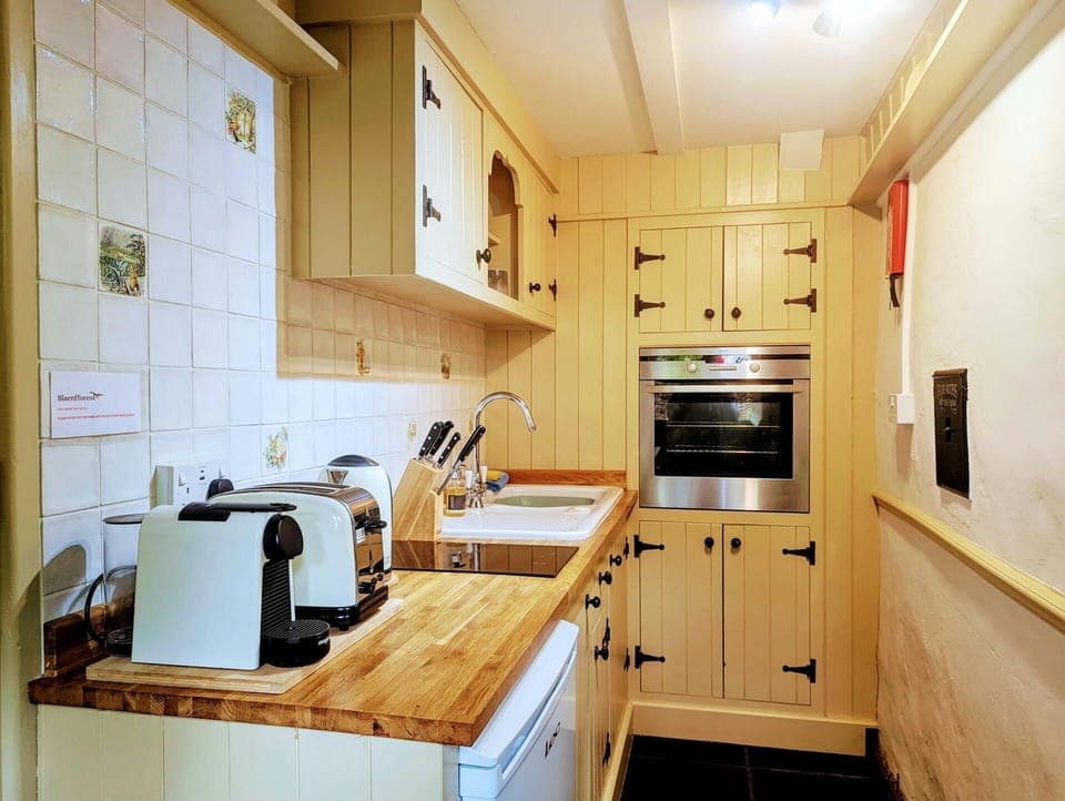 Kitchen with wooden units, hob, oven, toaster and kettle