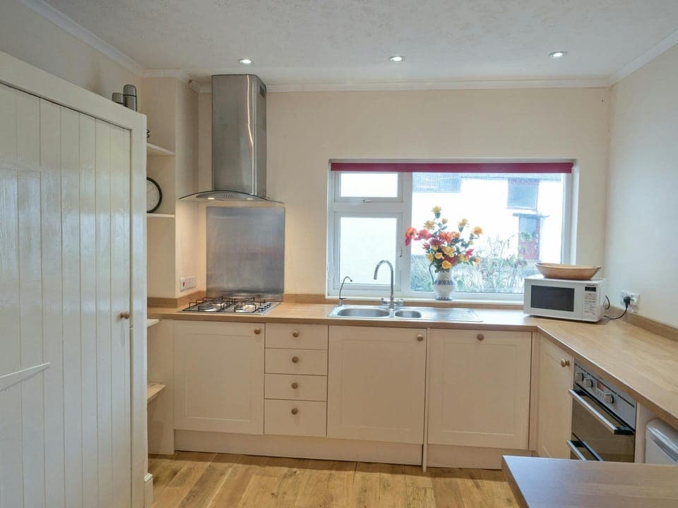 Fitted kitchen in Ffynnonddewi with hob, oven microwave and window