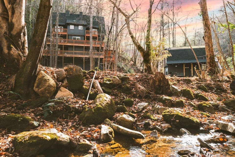 2 Cabins sit on 6 acres with tennis, pickleball and basketball basically on-site. Property hugs a creek throughout and is filled with a large lawn and 2 hot tubs!