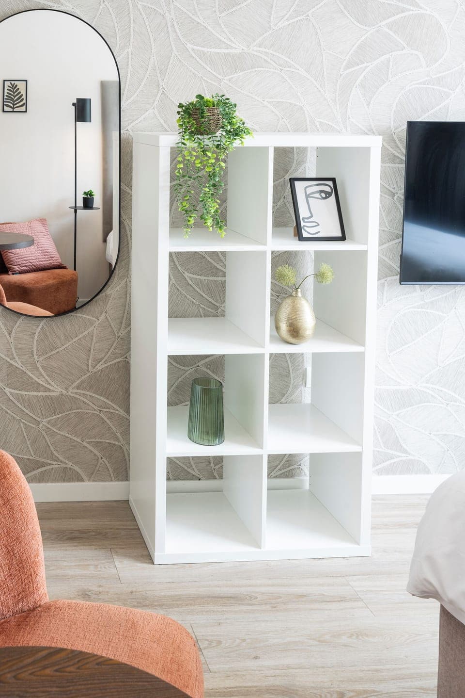  Elegant shelving unit with decorative accents and a mirror detail, enhancing the room's contemporary design.