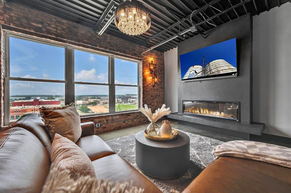 Immerse yourself in style with this living room, where stunning hardwood accents beautifully complement plush gray furniture and a chic camel leather sofa, creating a warm and inviting atmosphere.