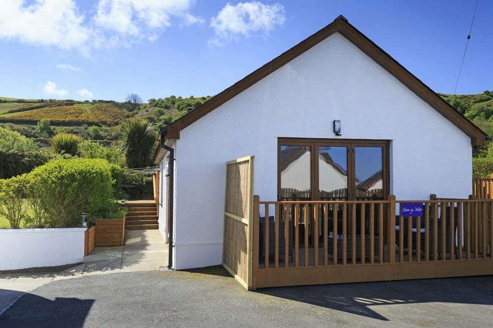Outside view of Swn y Mor with deck area and steps to the side