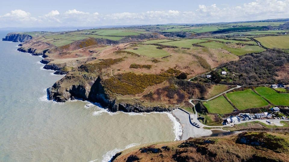 Drone view of Cwm Tydu beach, village and coastline