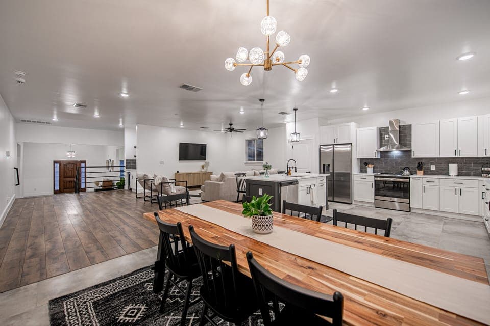The dining table is large enough for a group plus additional seating at the bar