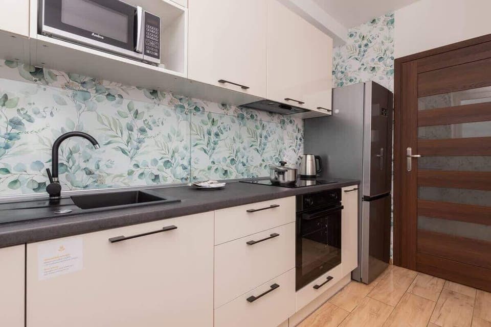 Fully equipped kitchen with upper and lower cabinetry, backsplash and dining area.