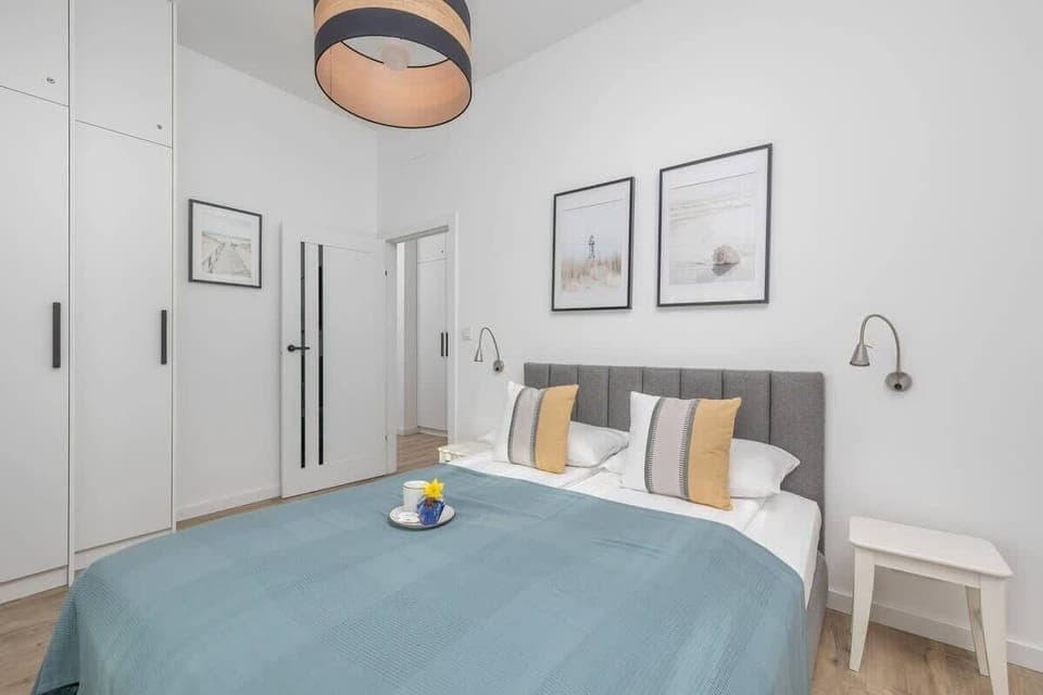 Cozy bedroom with a large bed, decorative pillows, and a wall clock.