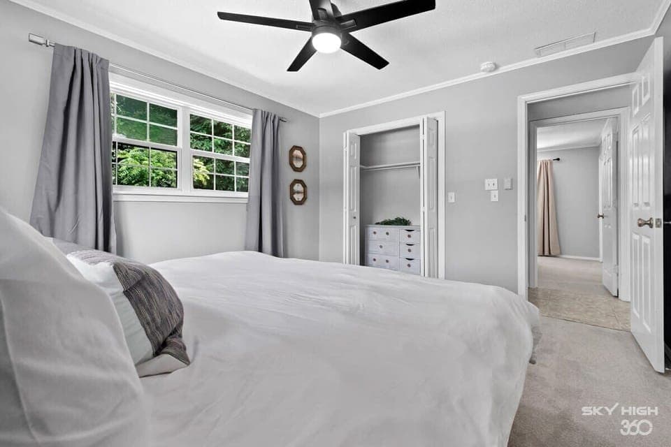Spacious bedroom with queen bed and ceiling fan—ideal for restful mornings.