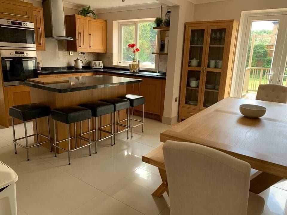 Modern, stylish kitchen diner with island and dining area, patio doors to the garden 