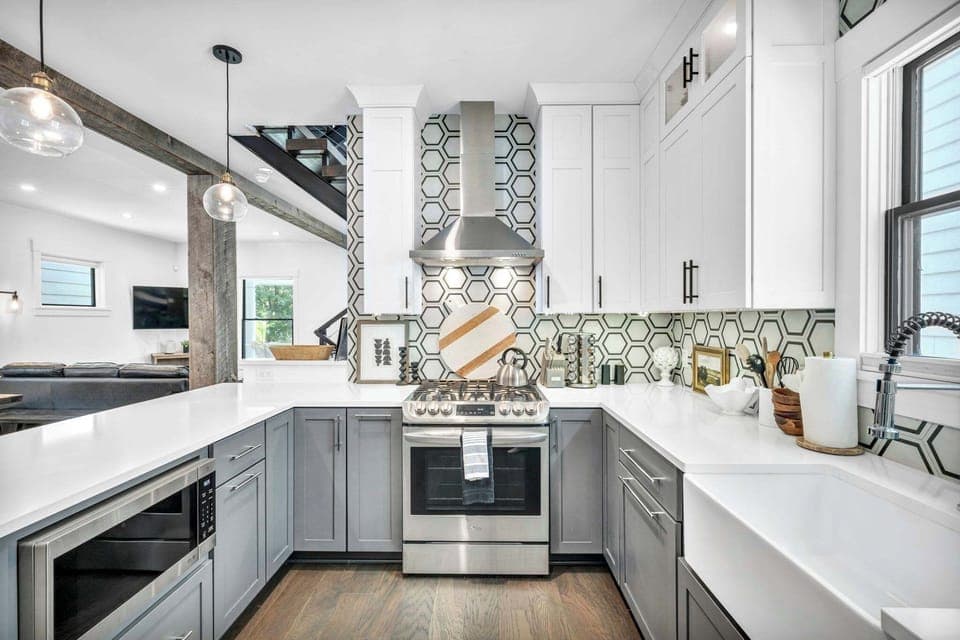 Experience the sleek design of our fully equipped kitchen, featuring stainless steel appliances, ample counter space, and a chic hexagonal tile backsplash. Perfect for preparing meals and making lasting memories.