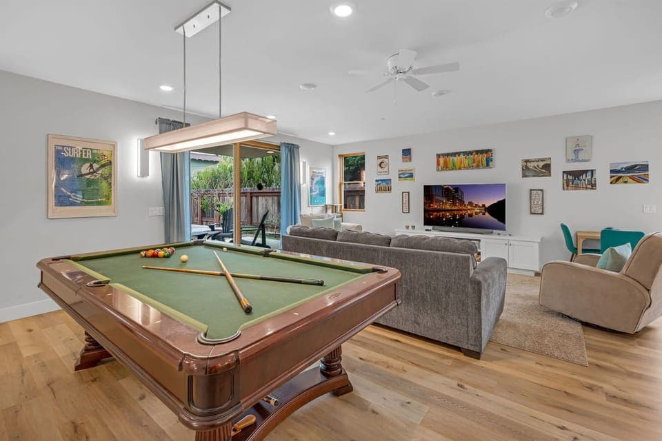 Downstairs living area: pool table, smart TV, kitchenette, direct access to the back patio and alley.