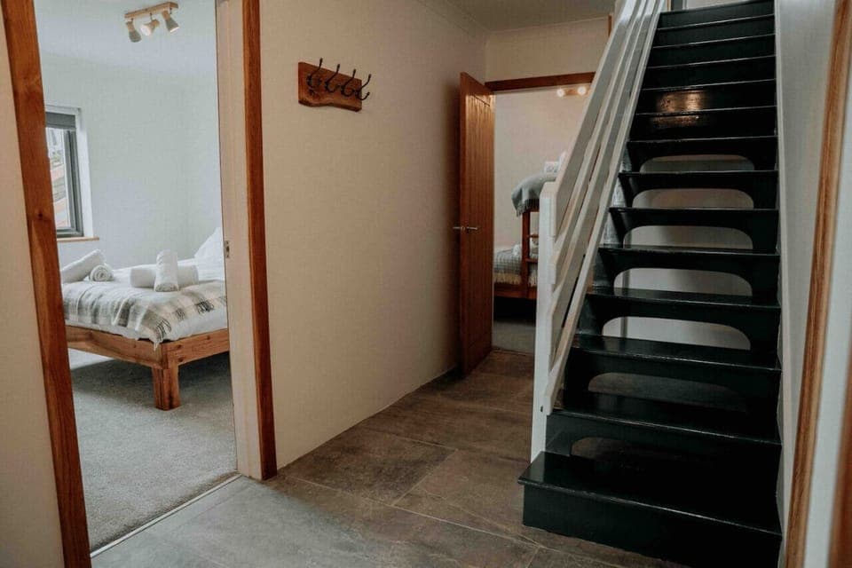 Ty Melyn Newgale – Welcoming entrance hall with stylish staircase leading to the spacious upstairs living areas.