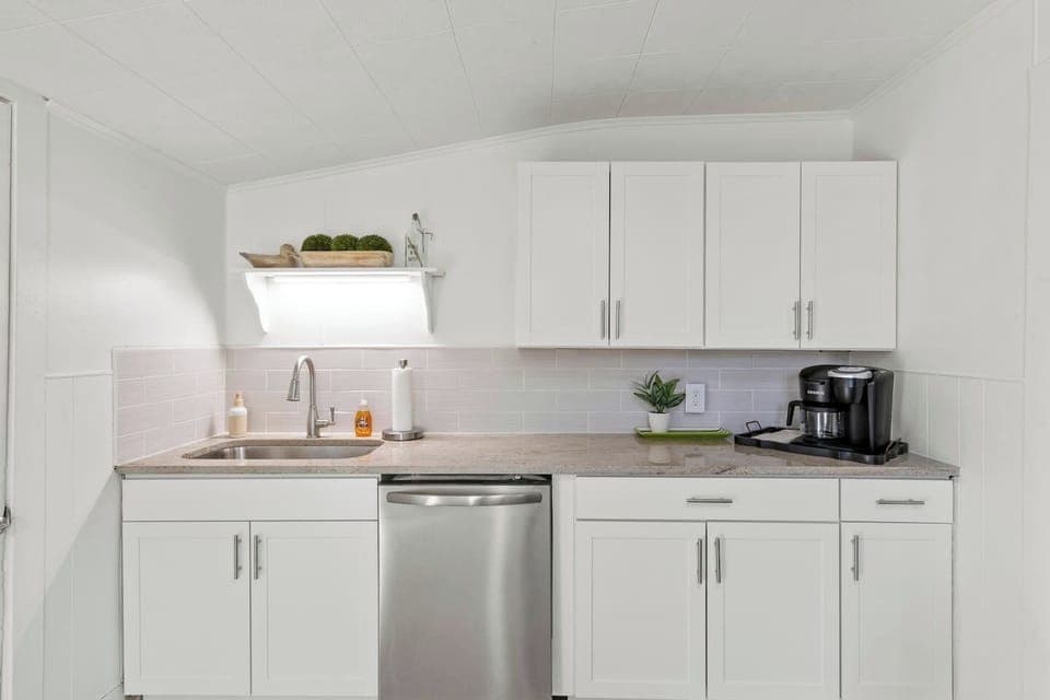 Kick-start your mornings in our chic, minimalist kitchen with a quick cup of coffee and serene decor accents.