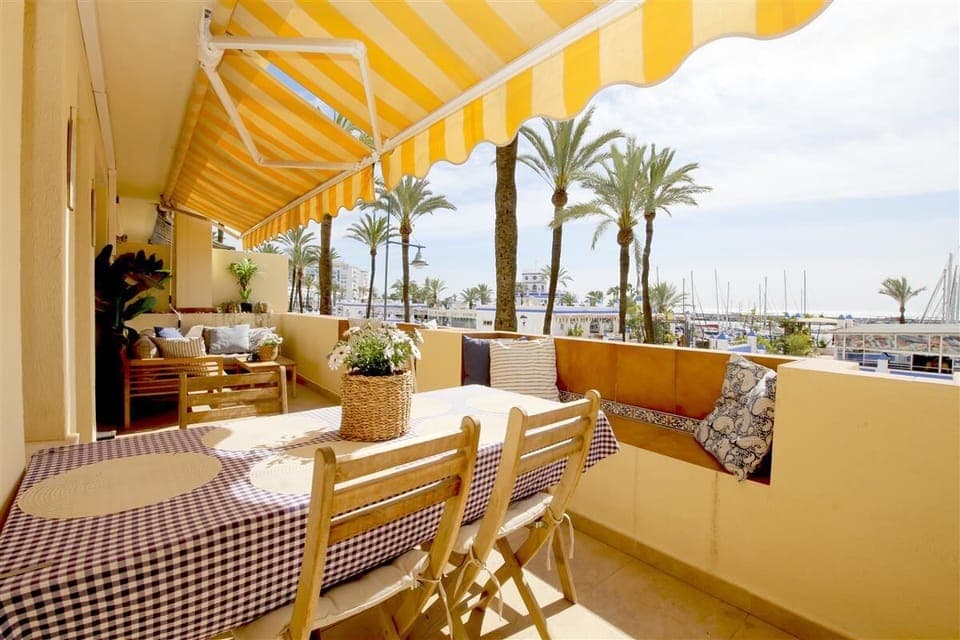 Large south facing balcony with outdoor seating, dining area for four guests and sea views