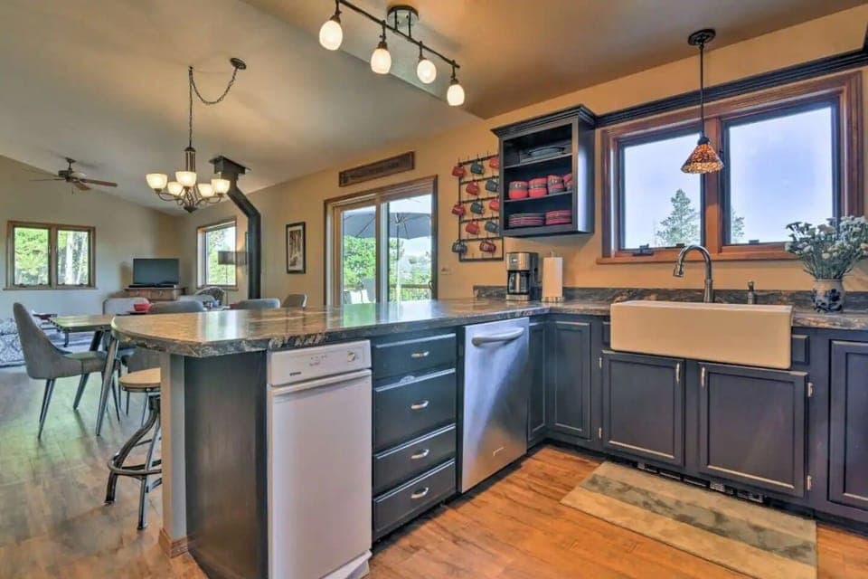 Kitchen with farm sink, dishwasher, trash compactor, fridge, & electric range