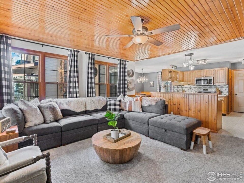 Open living room, kitchen, and dining room with door to patio and river.jpg