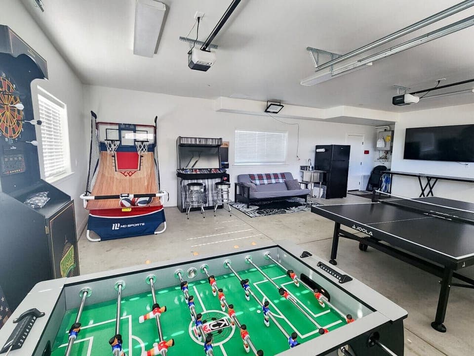 Front home game room with basketball, ping pong, foosball, dart board, arcade game with 4,000+ games, smart TV, beer pong & futon.