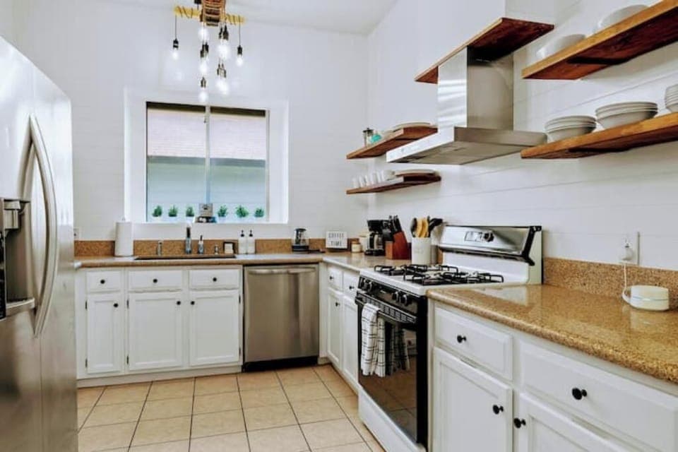 Fully stocked kitchen with stainless steel appliances.