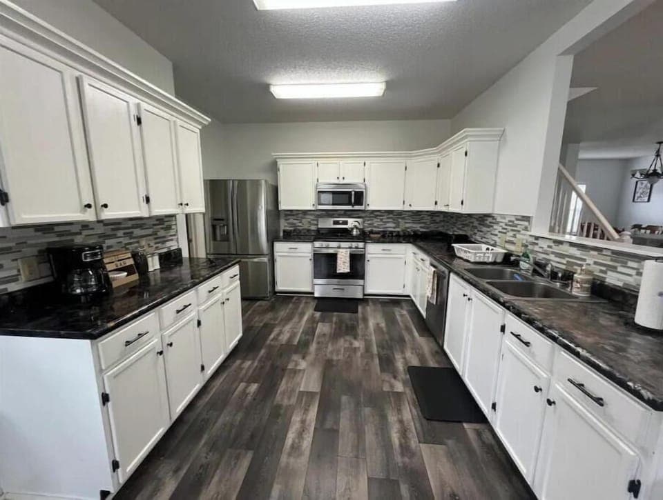 Fully stocked kitchen with appliances, cookware, and kids’ dinnerware.