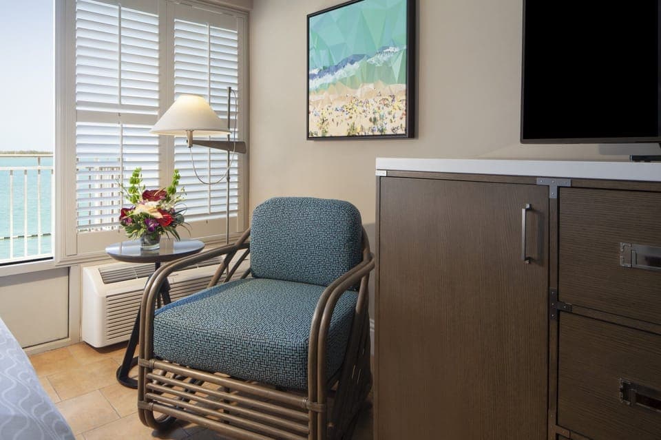 Relax in a cozy reading chair beside sunlit windows.