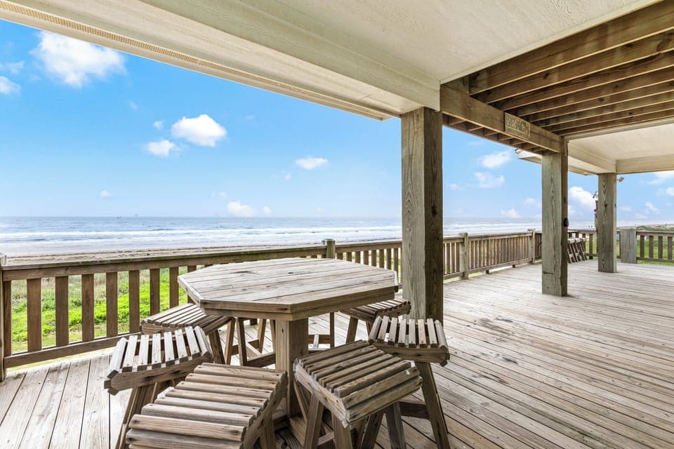 Spacious deck overlooking the beach with dining area. 