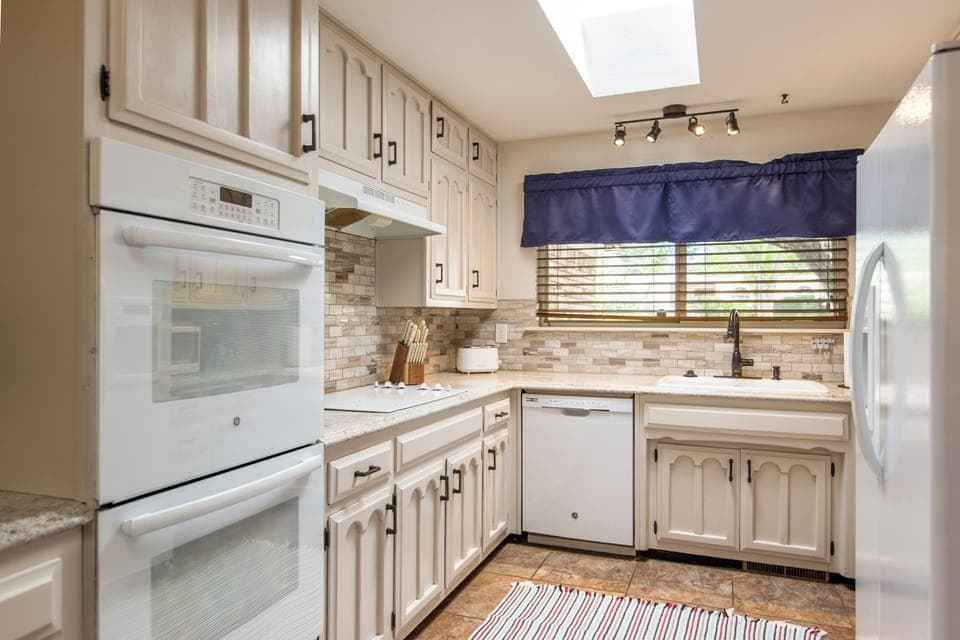 Fully equipped kitchen with all-white interior