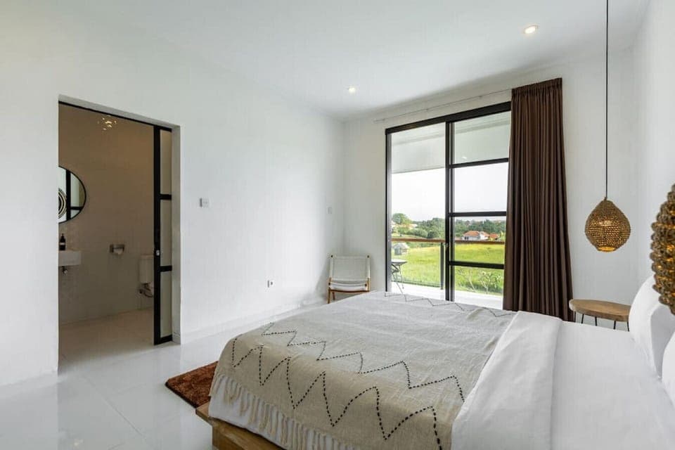 Serene bedroom with artisanal decor and countryside views.
