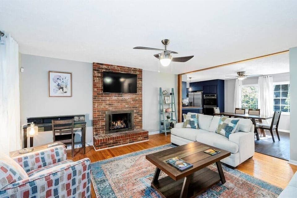 Living room with a very comfortable couch (sleeper sofa), loveseat, cozy chair, gas log fire place, flat screen TV and a desk for a dedicated workspace.