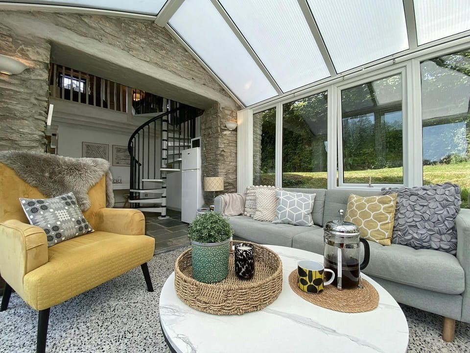 Conservatory with sofa and armchair. Coffee table