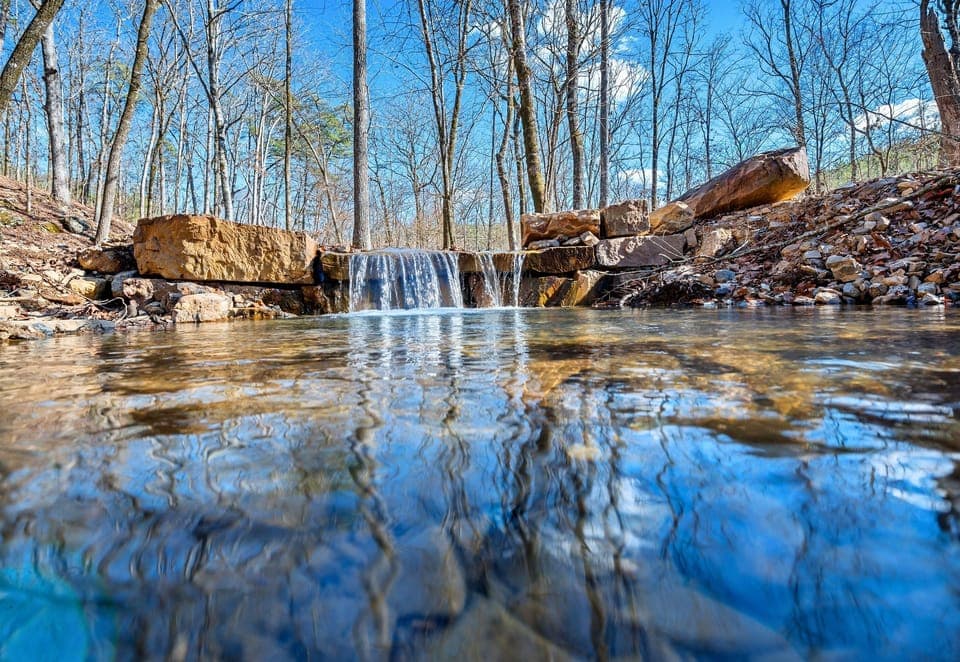 A scenic stream winds its way through the property, adding to the natural beauty and peaceful atmosphere.