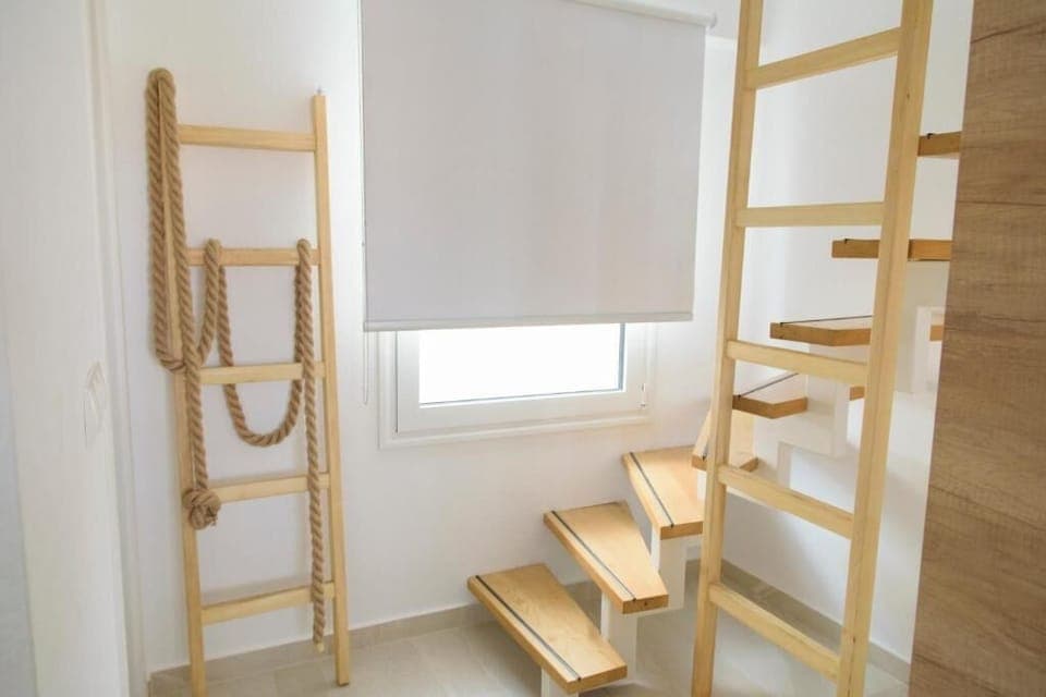 Interior staircase to upper floor – Wooden stairs with natural light and minimal railing.


