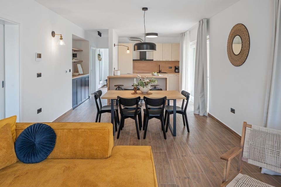 A fully functional kitchen with a kitchen island and balcony, a dining table that seats six