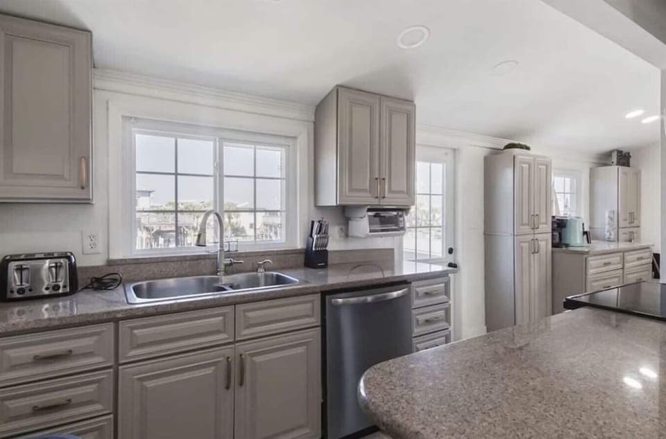 Your fully equipped kitchen invites culinary adventures with granite countertops, stainless steel appliances, and bright natural light streaming through windows.