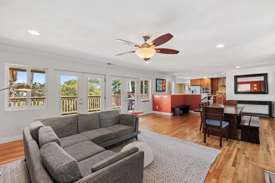 First Living Area (AC, ceiling fan, TV, large windows, dining area, fireplace)