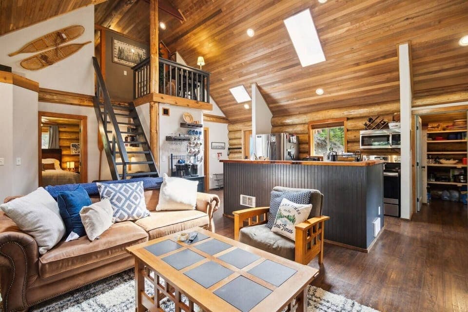 Spacious open living room and kitchen with vaulted ceilings and skylights.